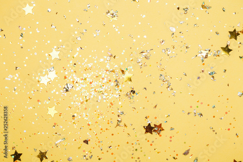 Colorful yellow confetti background. Vibrant and holiday. Top view, flat lay.
