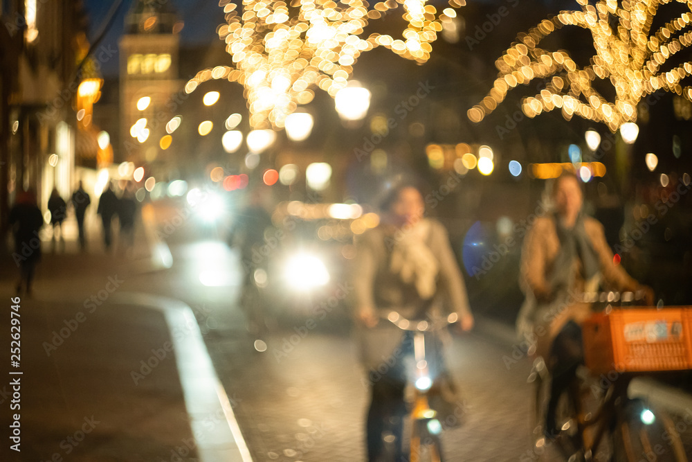 women cyclists ride down the street at night, bokeh and blur