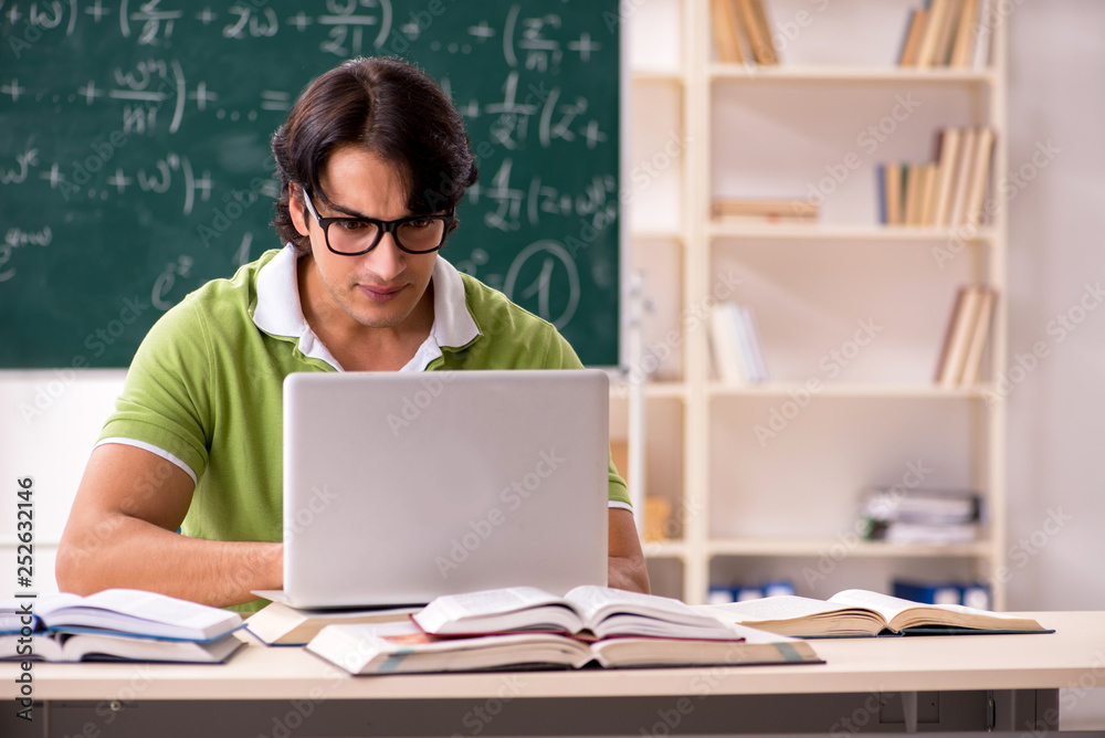 Handsome student in front of chalkboard with formulas Handsome student in front of chalkboard with formulas