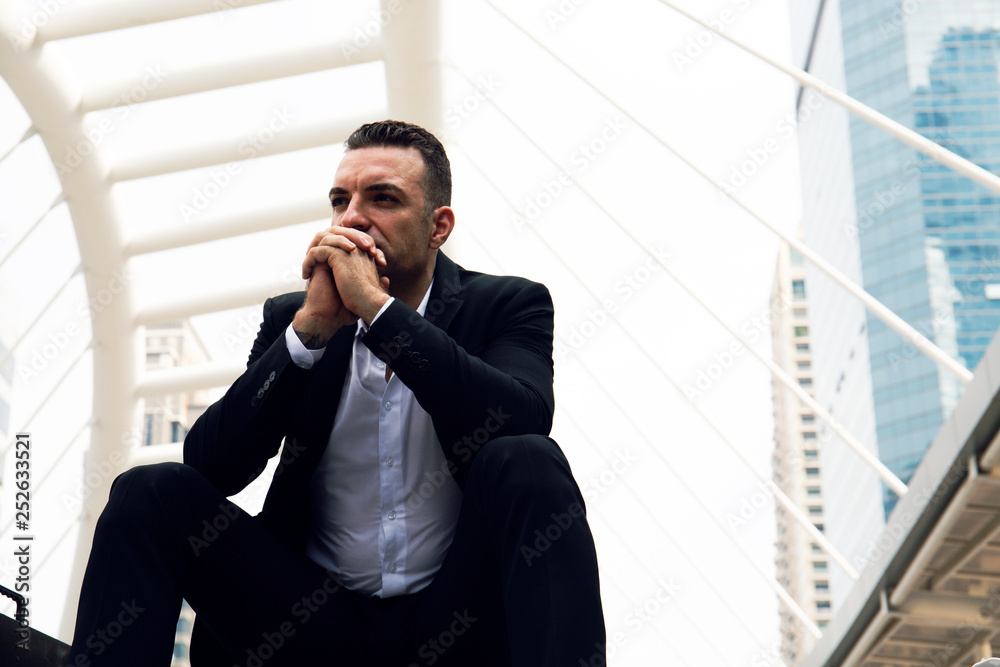 Business man sitting and thinking at outdoor in the city. Business man sitting and thinking at outdoor in the city.
