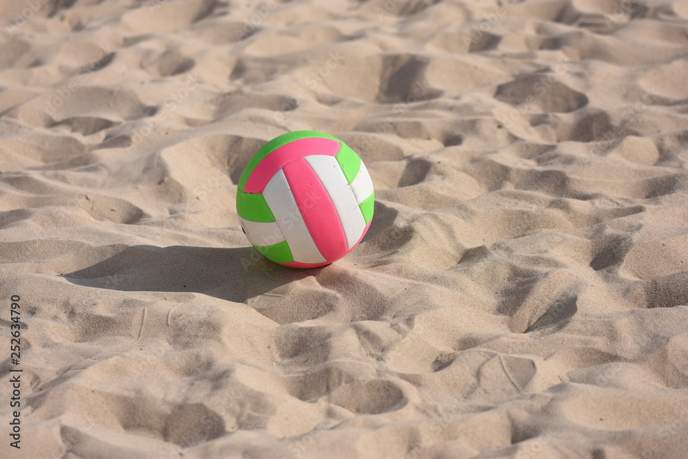 Pelota de voleyball en la arena de la playa bajo el sol