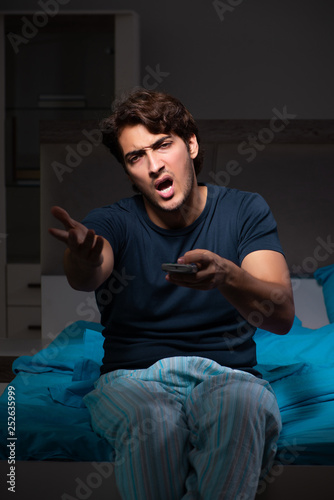 Man watching tv at night in bed