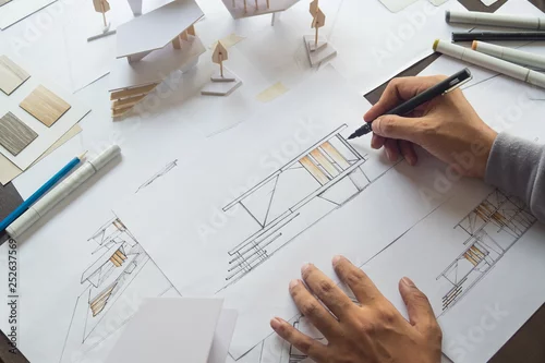 Obraz architect design working drawing sketch plans blueprints and making architectural construction model in architect studio