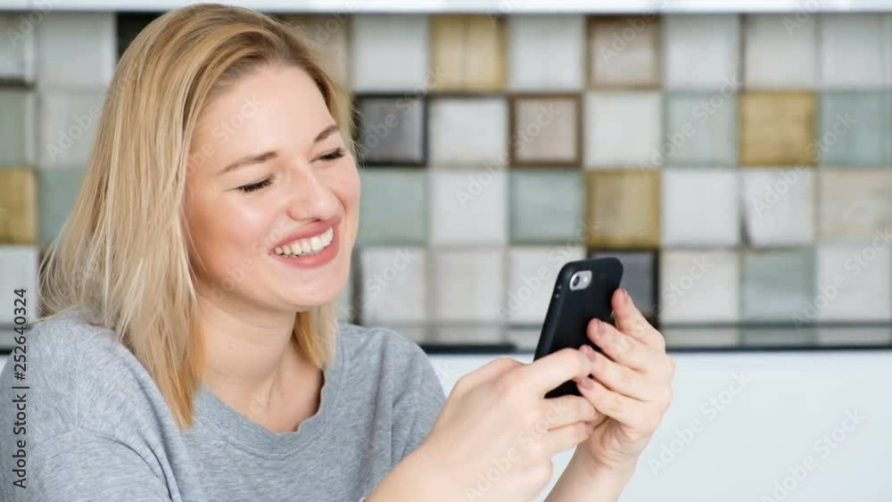 Portrait of a charming young blonde girl paying utility bills using an application in a smartphone. Concept of payment systems Portrait of a charming young blonde girl paying utility bills using an application in a smartphone. Concept of payment systems