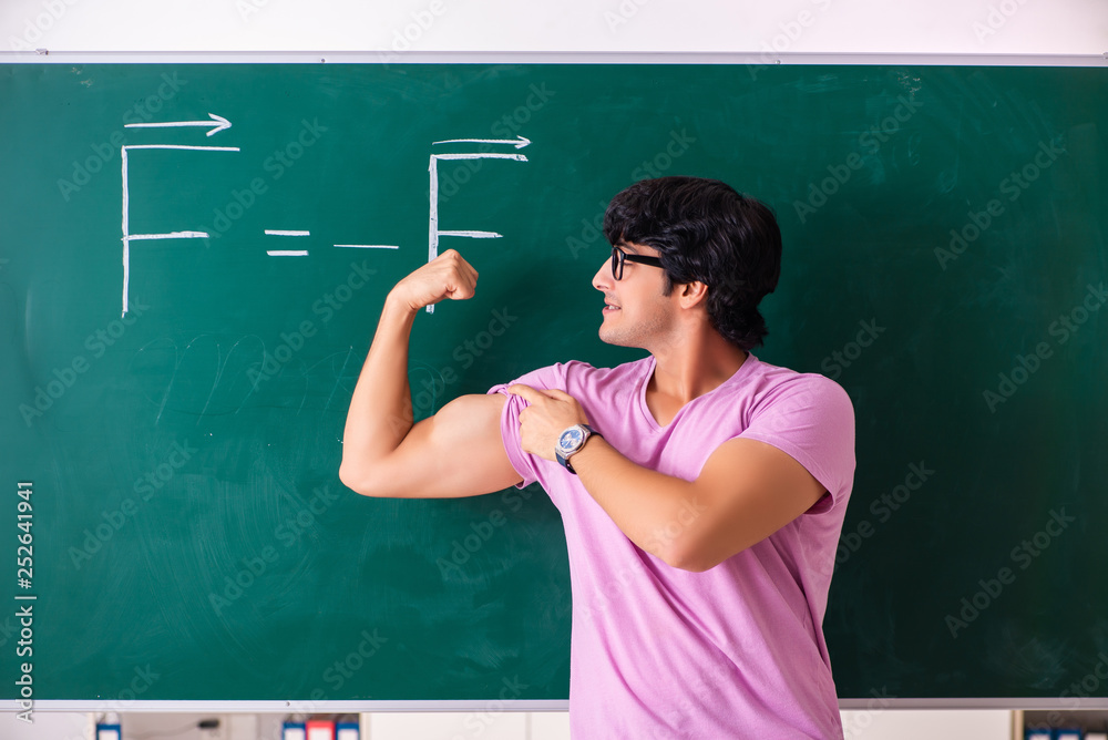 Young male physic standing in front of the green board