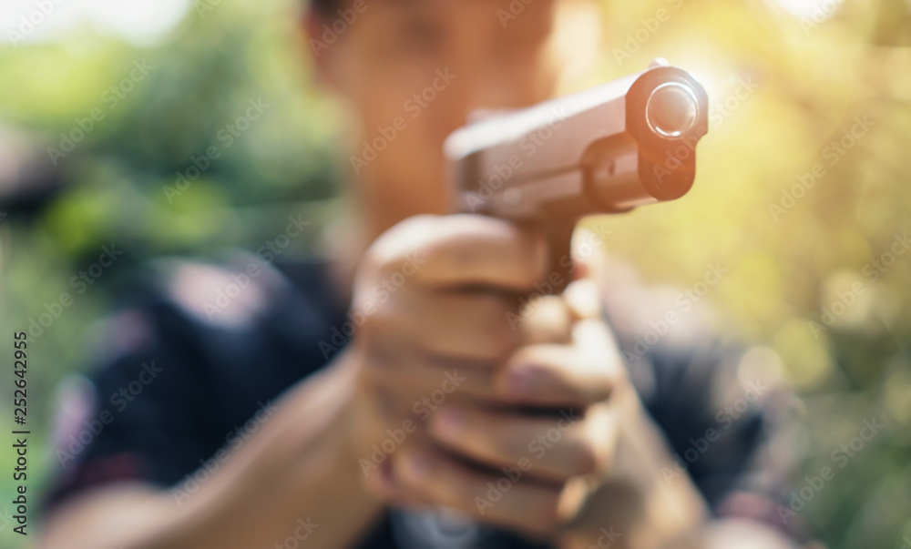 Close up men's pointing a gun at the target , selective focus on front gun, vintage color ton