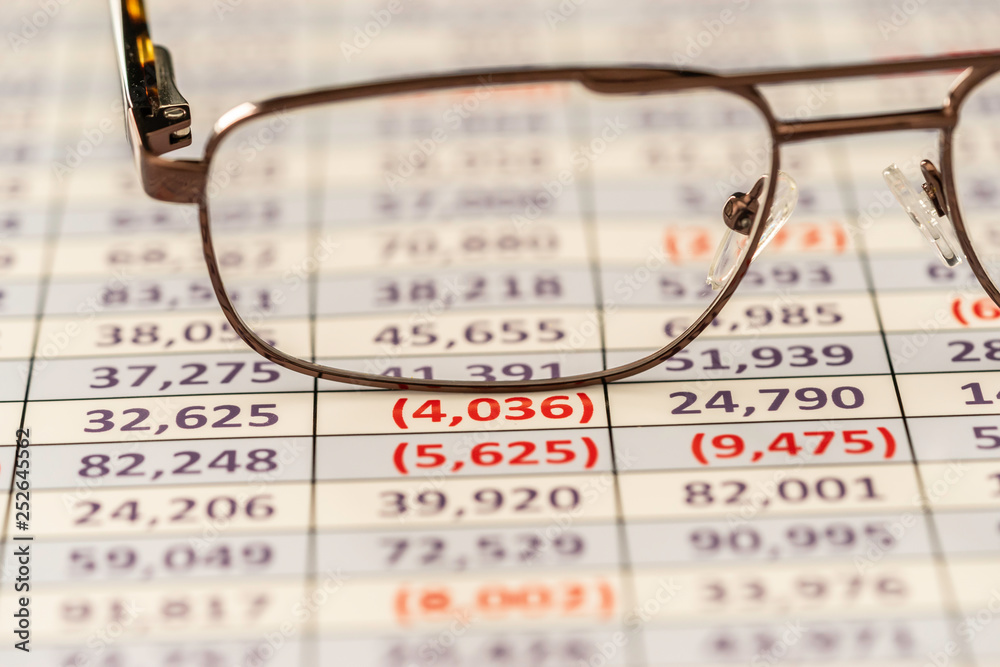 Reading glasses used to review spreadsheet report Reading glasses used to review spreadsheet report