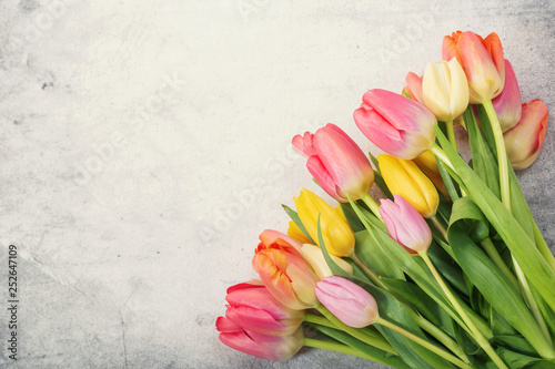 Bouquet of colorful tulips on grey table