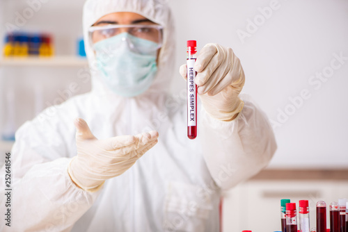 Tableau sur toile Young handsome lab assistant testing blood samples in hospital