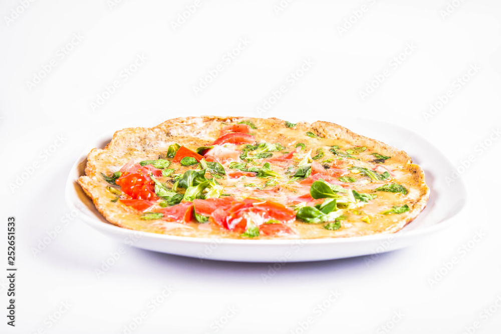 Omelette with tomatoes and fresh corn salad on a white background