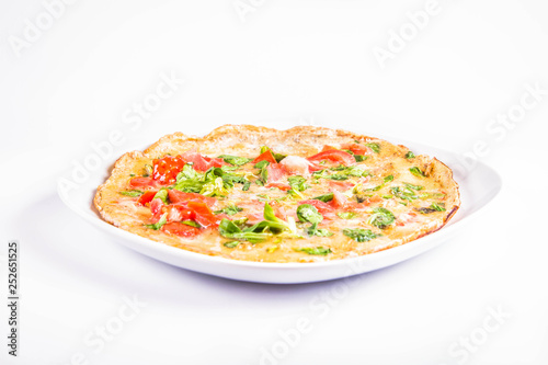 Omelette with tomatoes and fresh corn salad on a white background