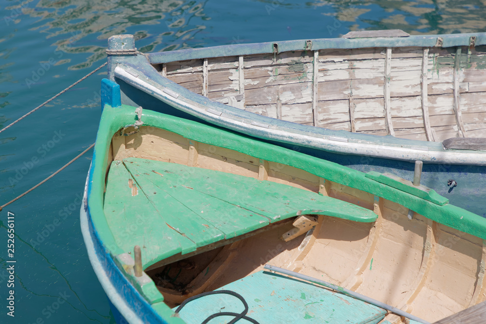 Closeup of colorful blue and green traditional fishing boats in the harbor in Malta
