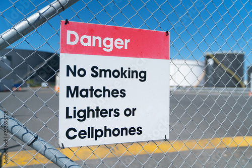 Danger sign on wire security fence to bulk petroleum storage tank yard.