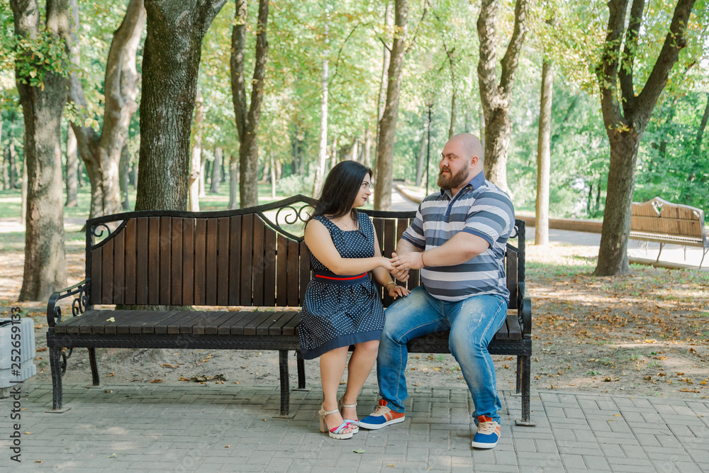 Two people in love sit on a bench in the park. Two people in love sit on a bench in the park.