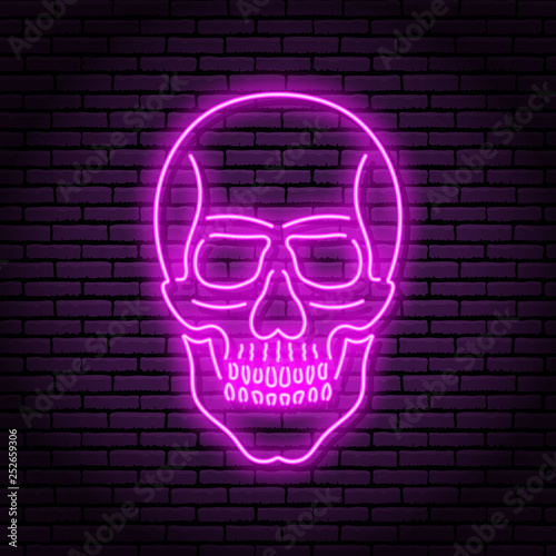The image of the skull of neon purple lamps with a bright glow on the background of a brick wall.