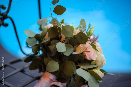 close up photo of a bridal bouquet from white and pink roses and eustoma on a iron chair photo