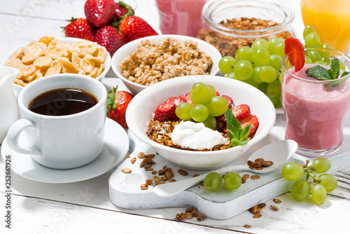 healthy breakfast with fruits, granola and milkshake on white background