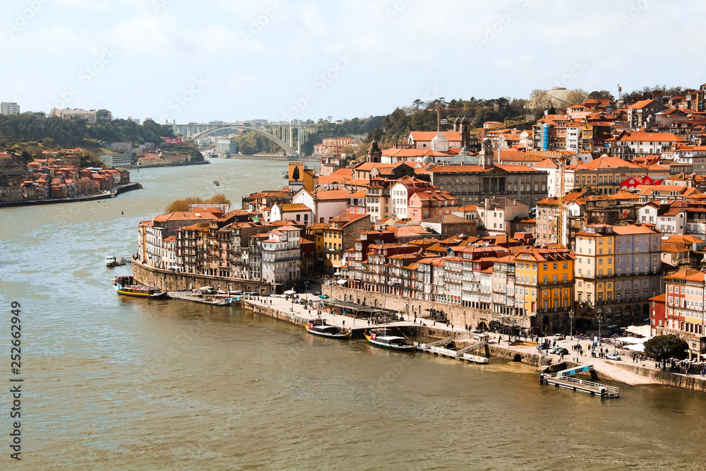 View onto the picturesque houses in the old town / old city of Porto with sunny sky and clouds as seen from Ponte Luís I (Porto, Portugal, Europe)