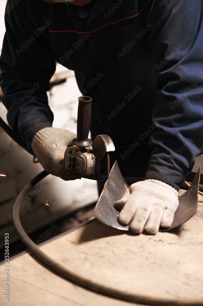 Close up of blacksmith grindering a metal plate