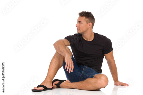 Serious Man Is Sitting Relaxed On A Floor And Looking Away