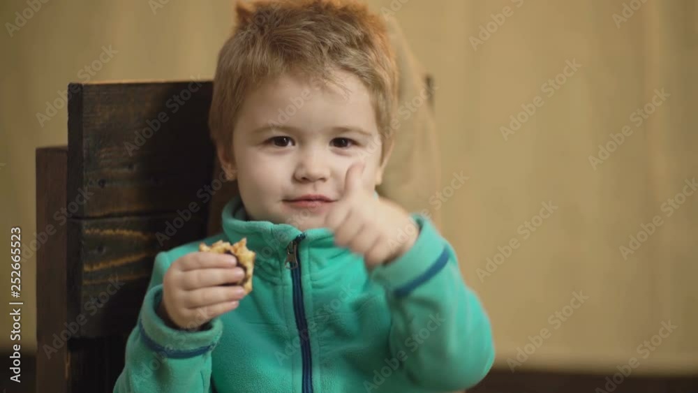 Wonderful little child eating pizza. Close up of a little boy who eats a delicious pizza and shows his pleasure with a thumbs up. Concept of fast food. Wonderful little child eating pizza. Close up of a little boy who eats a delicious pizza and shows his pleasure with a thumbs up. Concept of fast food.