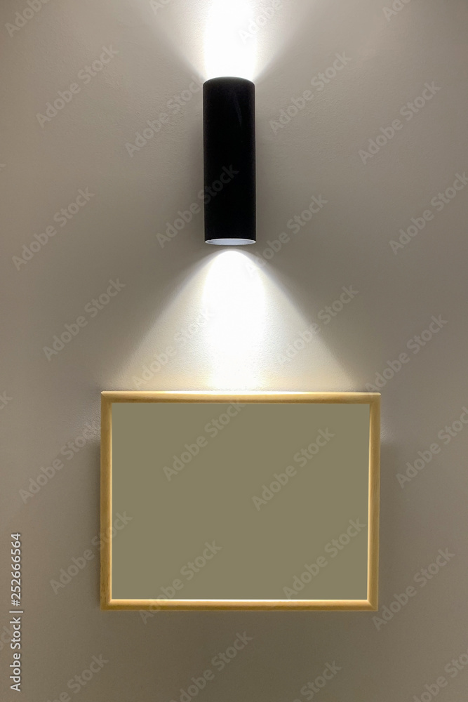 picture frame on the wall lit by a lamp picture frame on the wall lit by a lamp