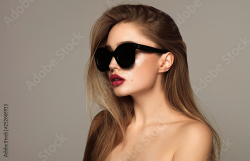 Portrait of young woman wear sunglasses with copy space isoalted over gray background