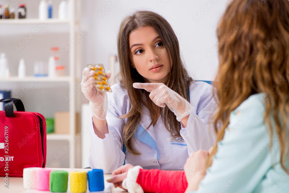 Female doctor traumatologist bandaging female patient Female doctor traumatologist bandaging female patient