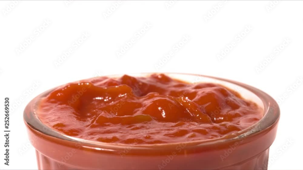 Man dips tortilla chip into red hot salsa sauce, close-up shot