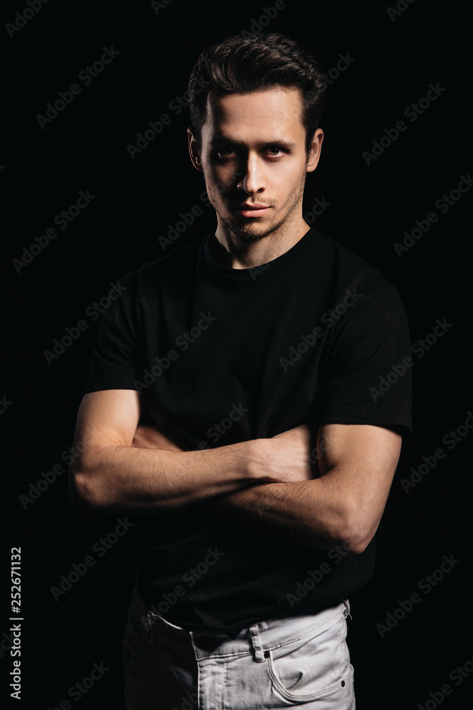 Handsome man, portrait of young man in a black t-shirt, black background Handsome man, portrait of young man in a black t-shirt, black background