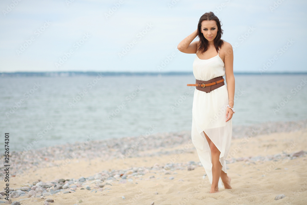 Gorgeous dark-haired girl in dress on sandy beach Gorgeous dark-haired girl in dress on sandy beach
