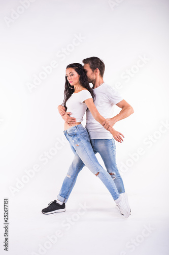 Young couple dancing social dance bachata, merengue, salsa, kizomba. Two elegance pose on white room.
