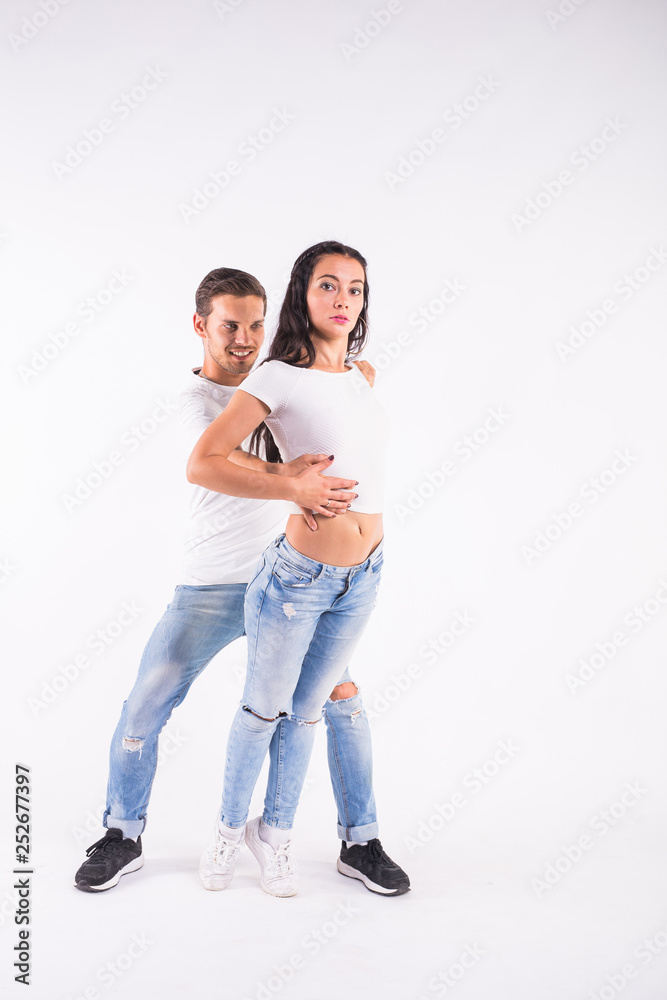 Young couple dancing social dance bachata, merengue, salsa, kizomba. Two elegance pose on white room.