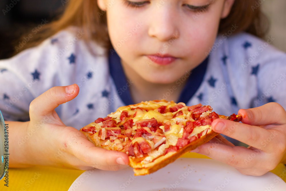 The child eats pizza. The child eats pizza.