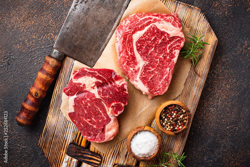 Raw marbled ribeye steak and butchers knife photo