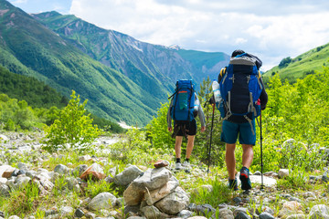 Friends walks in mountains. Journey in Alps mountain trail. Tourists on mountain trek