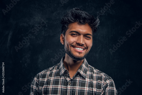 Photography Close-up portrait of a handsome Indian man wearing a plaid shirt, smiling and looking at a camera