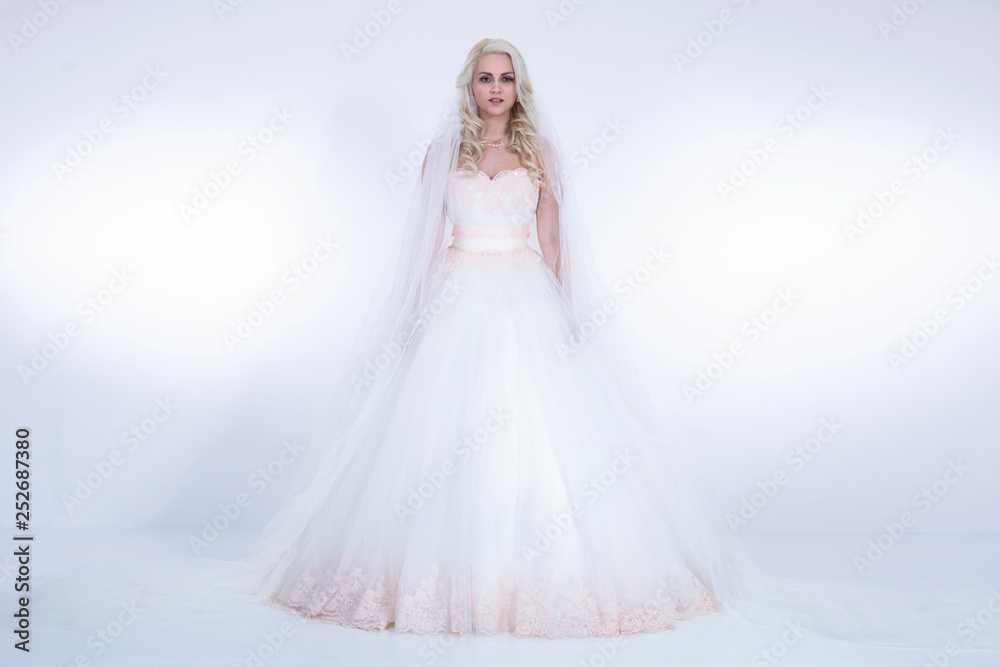 Naklejka premium Braut in weißem Brautkleid und Schleiher im Hellen strahlenden Licht Porträt