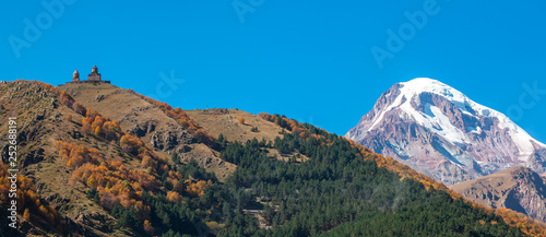 Mount Kazbek  Mkinvartsveri  and Gergeti church at sunny day. Caucasus mountains