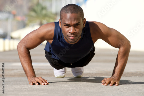 healthy young black man doing pushups outside