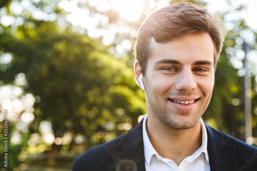 Close up of a smiling young business man walking Close up of a smiling young business man walking