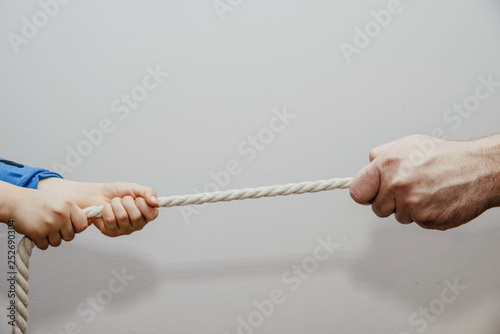 Dragging a child's rope with an adult. Conflict of children with adults. Concept of problems of children and adults. Misunderstanding of children and their needs, imposing the will of adult children.