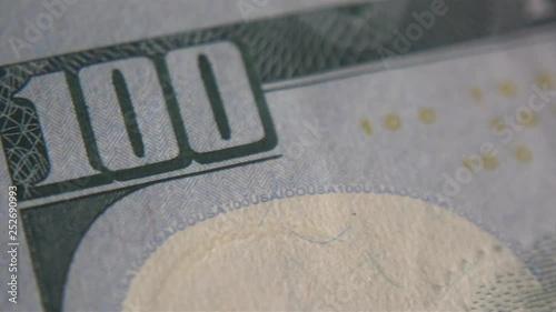 A hundred-dollar bill extremely macro camera movement. Financial independence and stock exchange. Cash in the hands of criminal structures.