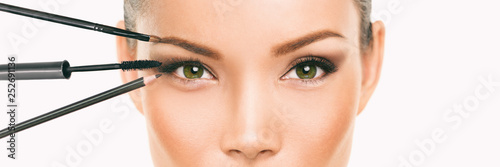 Tableau sur toile Eye makeup Asian woman professional make up artist applying mascara and eyebrow pencil makeover transformation
