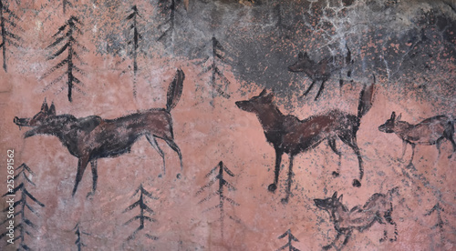 Prehistoric cave paintings - wolves and wood on beige stone