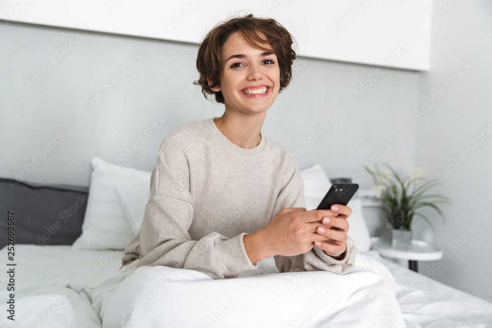 Smiling young girl relaxing in bed Smiling young girl relaxing in bed