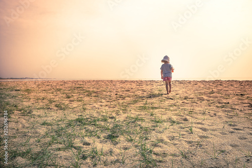 Lonely lost child toddler standing alone in sand dunes exploring childhood travel lifestyle 