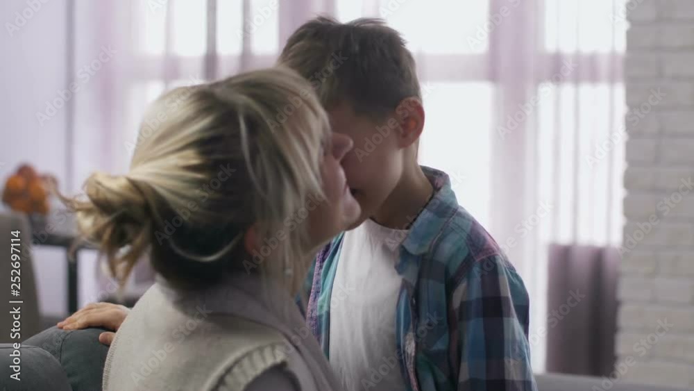Close up adorable preadolescent son and beautiful adult mother rubbing each other noses joyfully laughing in living room. Happy family having fun together, rejoicing holiday morning Close up adorable preadolescent son and beautiful adult mother rubbing each other noses joyfully laughing in living room. Happy family having fun together, rejoicing holiday morning