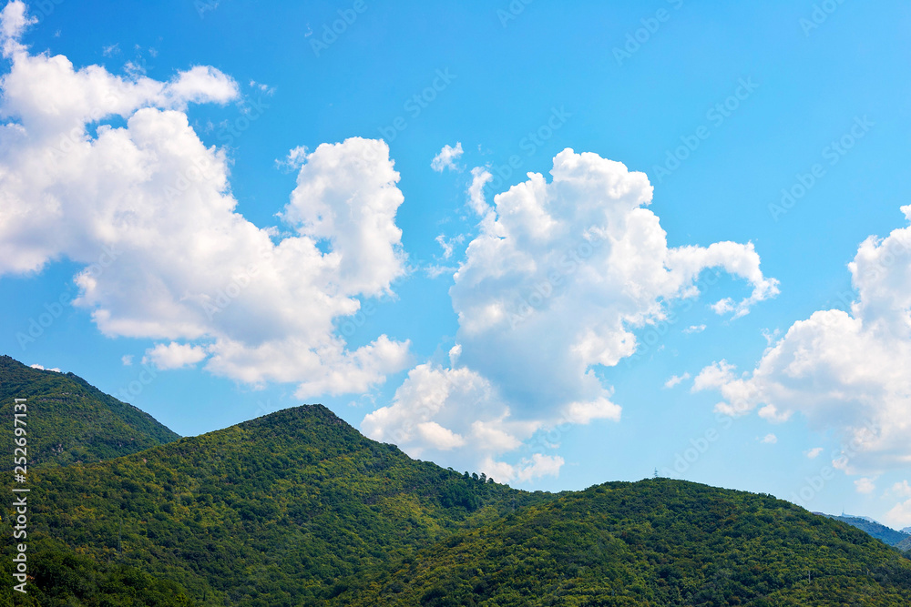 Incredible bright seascape. View of green wooded mountains and blue sea, blue sky and white clouds. Boka Kotorska Bay, Montenegro Incredible bright seascape. View of green wooded mountains and blue sea, blue sky and white clouds. Boka Kotorska Bay, Montenegro