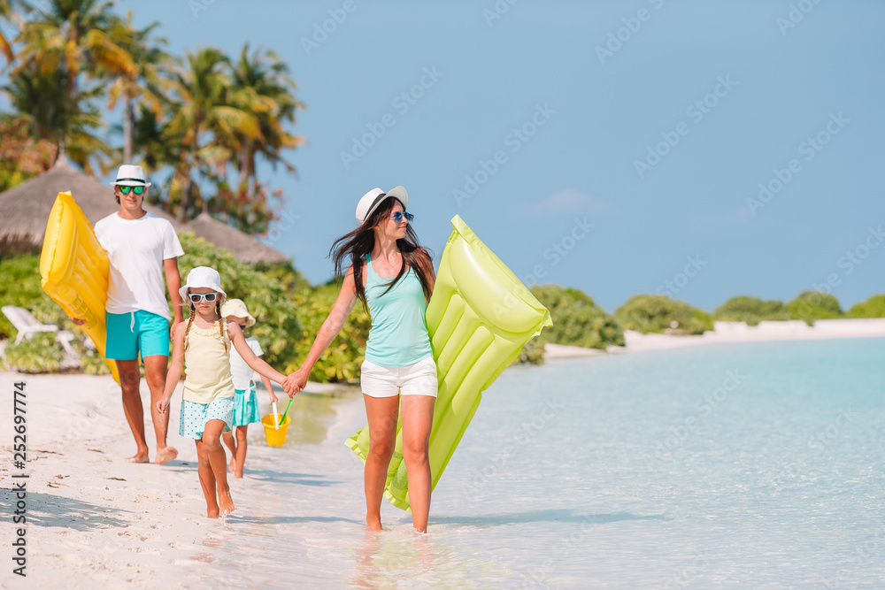 Family of four on beach vacation have fun